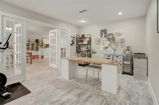 office space featuring light wood finished floors, baseboards, french doors, and visible vents