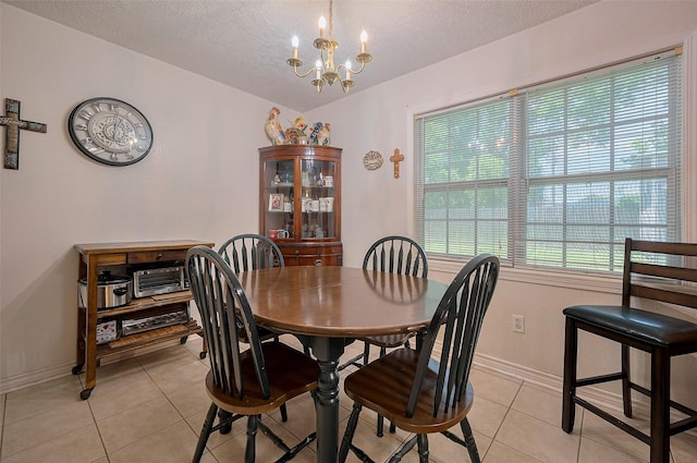 12735 Iroquois St, Houston, TX 77037 - dining space featuring an inviting chandelier, a textured ceiling, baseboards, and light tile patterned floors