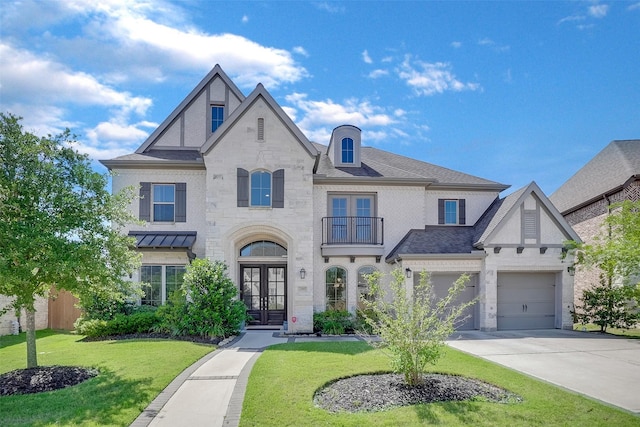 23907 Birchwood Lake Ln, Katy, TX 77493 - view of front of house with french doors, a balcony, a front lawn, concrete driveway, and stone siding