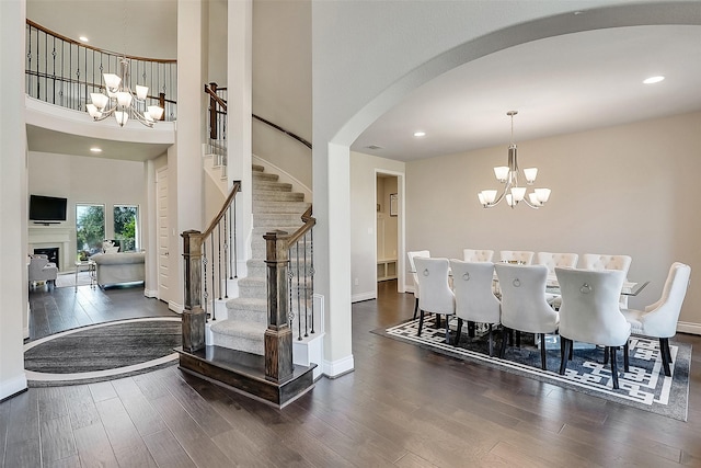 23907 Birchwood Lake Ln, Katy, TX 77493 - dining room with a chandelier, wood finished floors, stairs, arched walkways, and a high ceiling