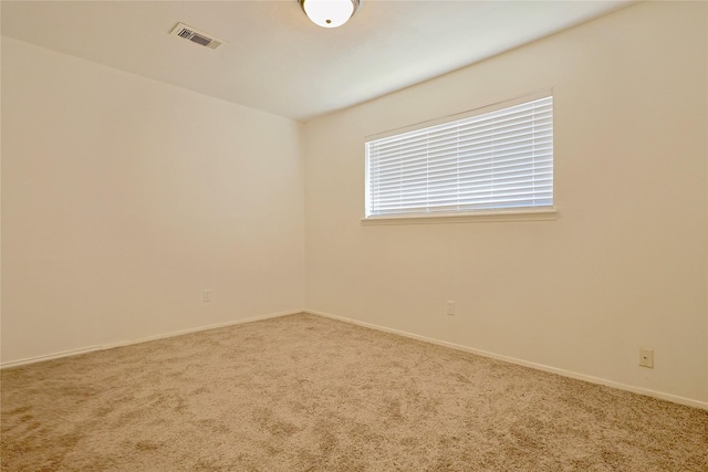 unfurnished room with carpet floors, baseboards, and visible vents