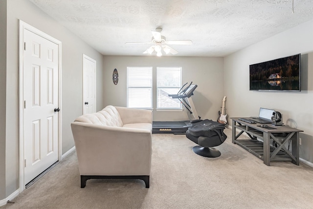 living room with carpet, a textured ceiling, baseboards, and ceiling fan