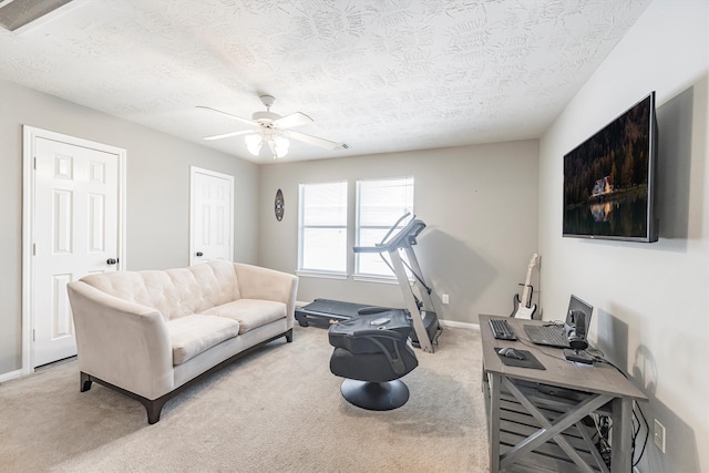 living area with a textured ceiling, a ceiling fan, and carpet floors