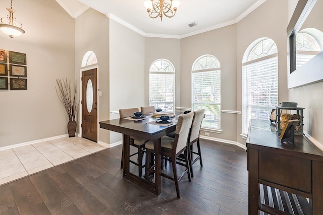 dining area with baseboards, ornamental molding, visible vents, a chandelier, and hardwood / wood-style flooring