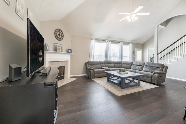 living area featuring vaulted ceiling, baseboards, and a ceiling fan