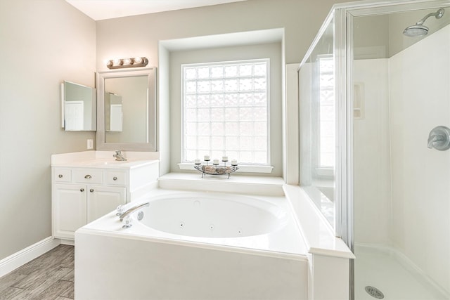full bath with a shower stall, baseboards, a jetted tub, and vanity