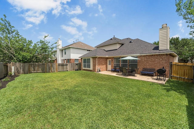 back of property featuring a lawn, a patio area, brick siding, and a fenced backyard