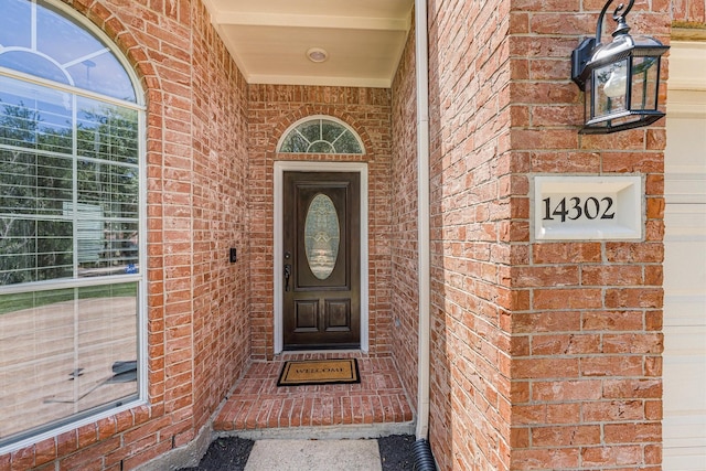 doorway to property featuring brick siding