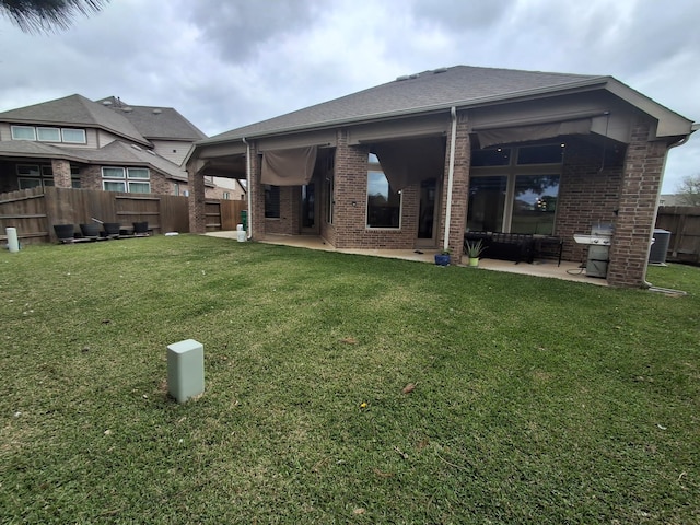 25215 Quiet Run Trl, Richmond, TX 77406 - rear view of house with brick siding, a fenced backyard, a lawn, and a patio area