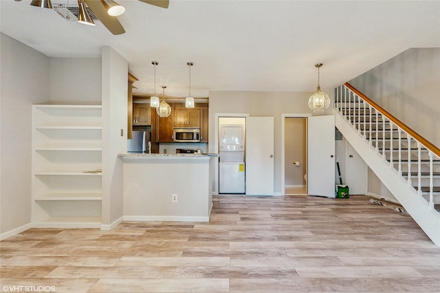 kitchen with a ceiling fan, stainless steel appliances, brown cabinetry, and light wood-style flooring