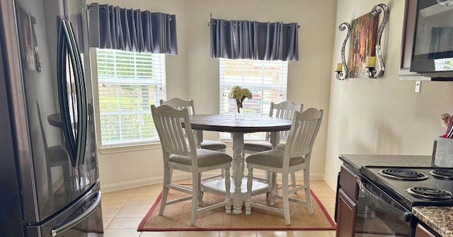 dining space with baseboards and light tile patterned floors