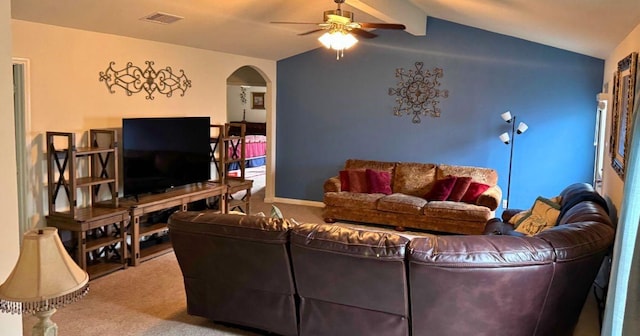carpeted living area with ceiling fan, lofted ceiling with beams, arched walkways, and visible vents