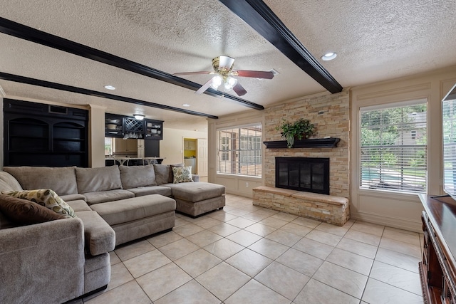 living area with a ceiling fan, a textured ceiling, light tile patterned floors, and beamed ceiling