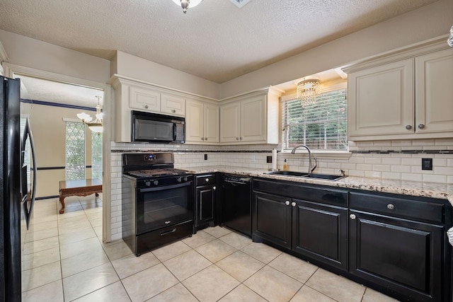 kitchen featuring a sink, a chandelier, black appliances, decorative backsplash, and dark cabinetry