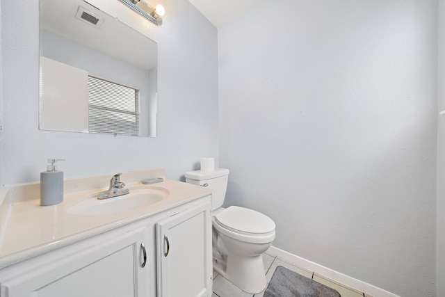 bathroom featuring toilet, vanity, visible vents, tile patterned floors, and baseboards