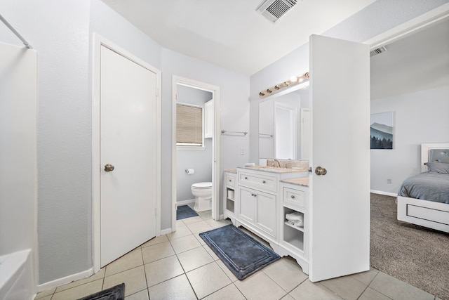 ensuite bathroom with toilet, ensuite bathroom, vanity, visible vents, and tile patterned floors