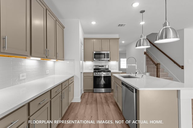 5042 Celestial Ct, La Marque, TX 77563 - kitchen with stainless steel appliances, a sink, light wood-type flooring, light countertops, and tasteful backsplash