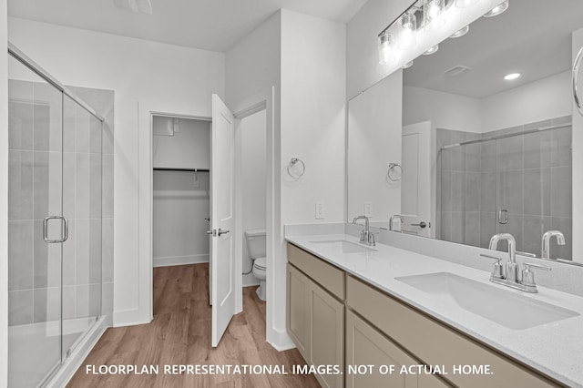 5042 Celestial Ct, La Marque, TX 77563 - bathroom featuring wood finished floors, a shower stall, toilet, and double vanity