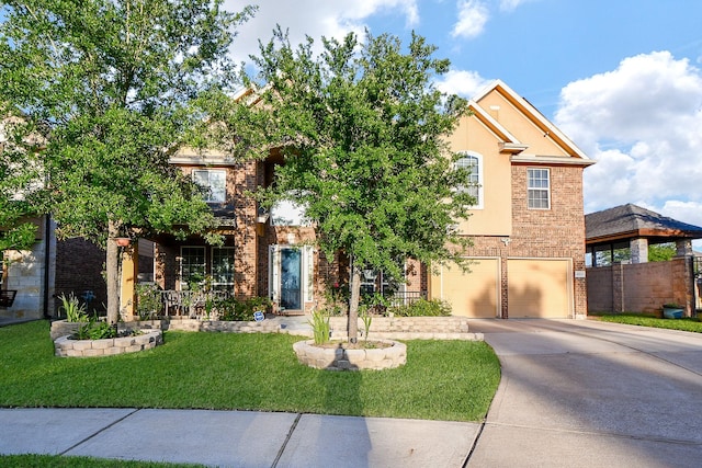 view of front of property featuring a garage, fence, a front lawn, brick siding, and driveway