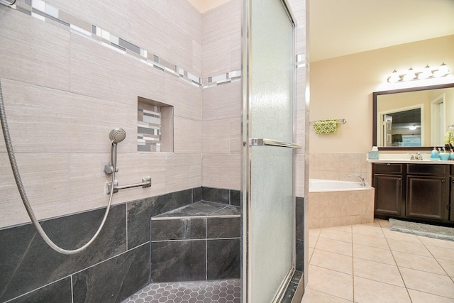bathroom featuring a shower stall, tile patterned floors, a garden tub, and vanity