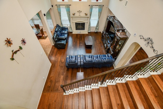 living room with visible vents, wood finished floors, and a glass covered fireplace