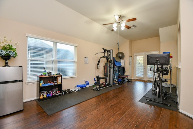 workout area with a ceiling fan, lofted ceiling, visible vents, and wood finished floors
