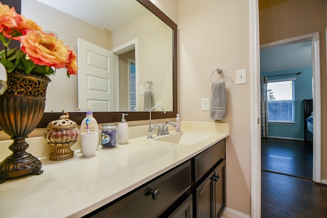 bathroom with baseboards, vanity, and wood finished floors