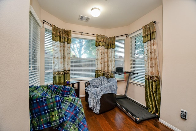 sitting room featuring baseboards, a wealth of natural light, visible vents, and wood finished floors