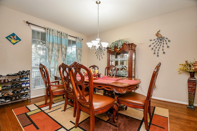 dining room featuring baseboards, a notable chandelier, and wood finished floors