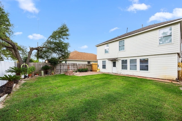 rear view of property with a yard, a fenced backyard, and a patio