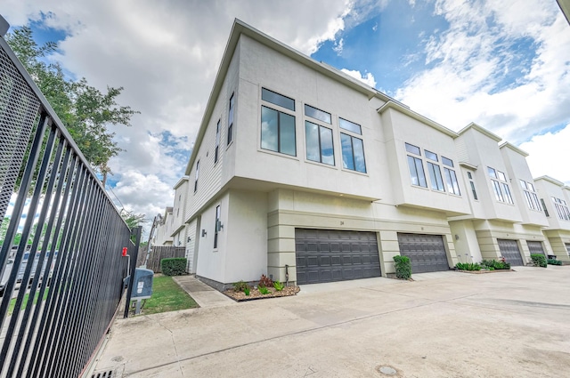 24 N Hutcheson St, Houston, TX 77003 - view of side of property with stucco siding, an attached garage, and concrete driveway