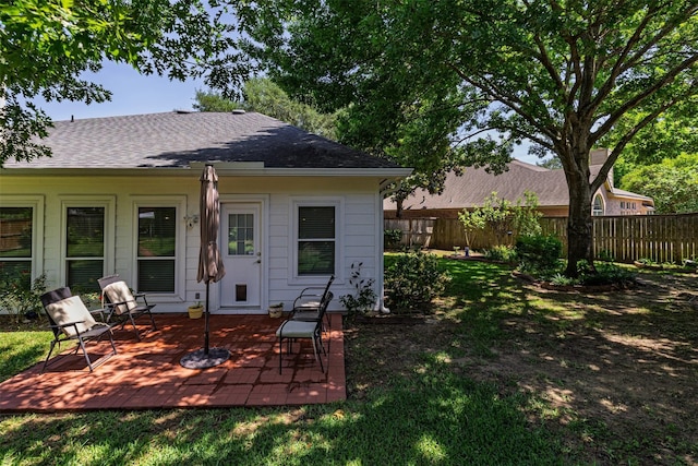 19231 Kelly Pines Ct, Humble, TX 77346 - back of house featuring a shingled roof, a patio, fence, and a yard