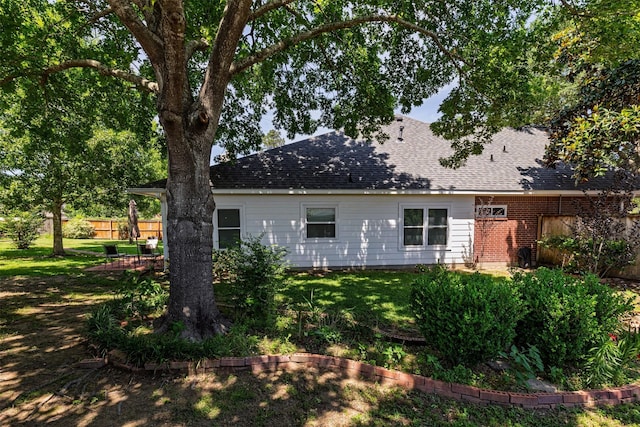 19231 Kelly Pines Ct, Humble, TX 77346 - back of house with a yard, brick siding, a shingled roof, and fence