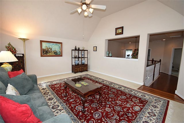 living area with baseboards, a ceiling fan, and high vaulted ceiling