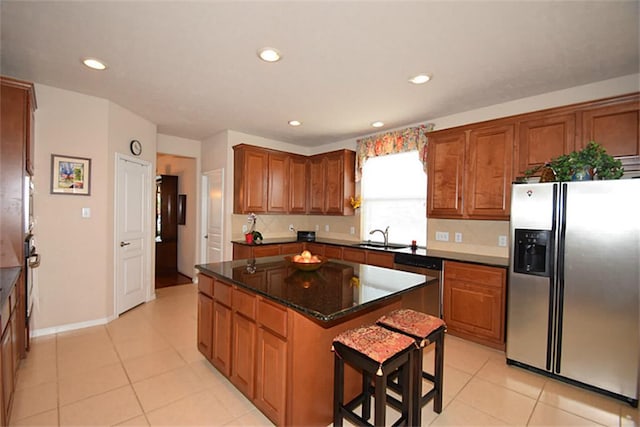 kitchen with recessed lighting, a sink, a kitchen island, brown cabinets, and stainless steel appliances