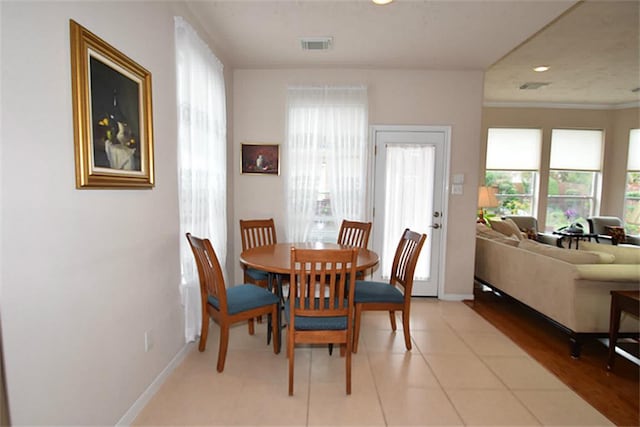 dining room featuring light tile patterned floors, visible vents, and baseboards