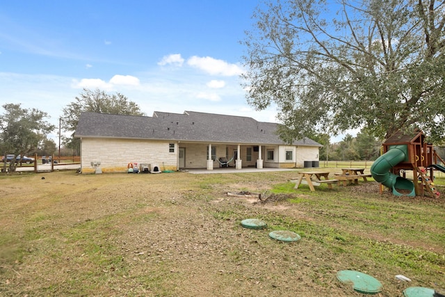 19503 Fisher Dr, Tomball, TX 77377 - back of house with a yard, a patio area, stone siding, and a playground