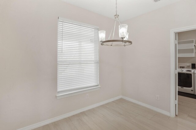 19503 Fisher Dr, Tomball, TX 77377 - unfurnished dining area with washer / dryer, an inviting chandelier, and baseboards