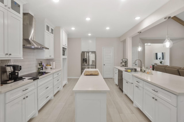19503 Fisher Dr, Tomball, TX 77377 - kitchen featuring a peninsula, stainless steel appliances, wall chimney range hood, decorative backsplash, and a kitchen island