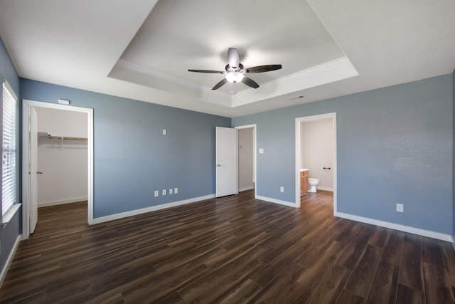 15319 Sableton Crest Ln, Cypress, TX 77429 - unfurnished bedroom with a tray ceiling, visible vents, dark wood-style flooring, baseboards, and a spacious closet