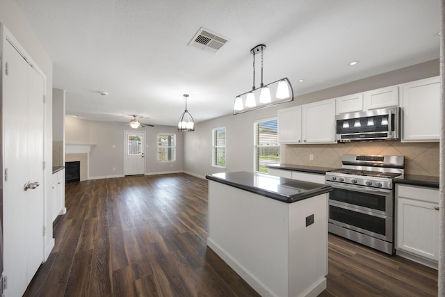 15319 Sableton Crest Ln, Cypress, TX 77429 - kitchen featuring a center island, dark countertops, stainless steel appliances, visible vents, and tasteful backsplash
