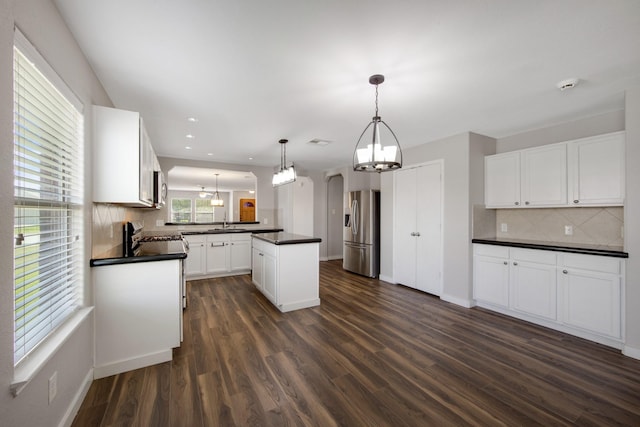 15319 Sableton Crest Ln, Cypress, TX 77429 - kitchen with a notable chandelier, a sink, dark countertops, stainless steel appliances, and tasteful backsplash