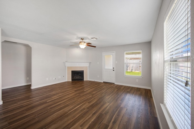 15319 Sableton Crest Ln, Cypress, TX 77429 - unfurnished living room featuring a tiled fireplace, dark wood finished floors, visible vents, baseboards, and ceiling fan