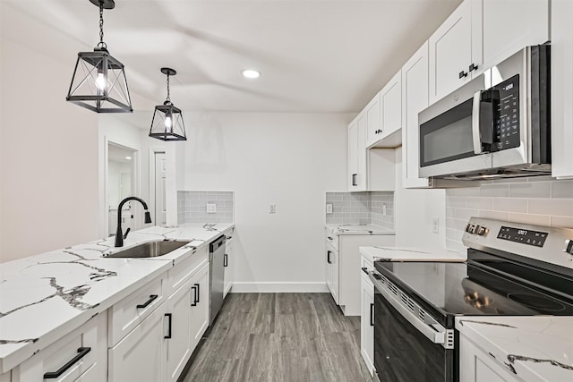 kitchen featuring a sink, stainless steel appliances, backsplash, and light stone countertops