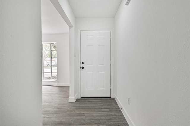 doorway to outside with wood finished floors and baseboards
