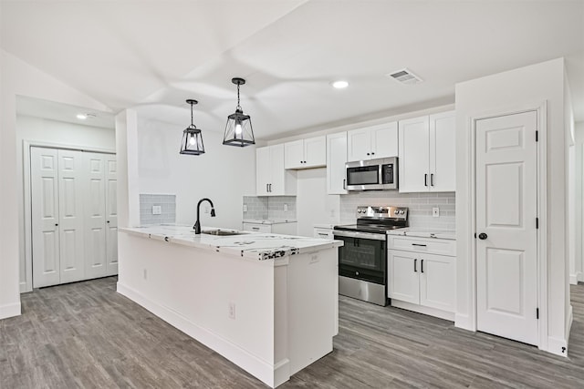 512 Stoneledge Dr, Friendswood, TX 77546 - kitchen featuring appliances with stainless steel finishes, wood finished floors, decorative backsplash, a sink, and white cabinets