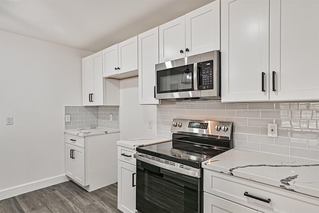 512 Stoneledge Dr, Friendswood, TX 77546 - kitchen featuring stainless steel appliances, light stone countertops, dark wood finished floors, white cabinets, and decorative backsplash