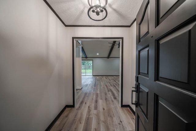213 Westview Dr, Sealy, TX 77474 - corridor with an inviting chandelier, a textured ceiling, baseboards, and light wood finished floors
