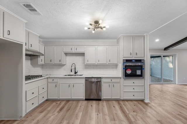 213 Westview Dr, Sealy, TX 77474 - kitchen featuring stainless steel appliances, light wood-type flooring, light countertops, a chandelier, and a textured ceiling