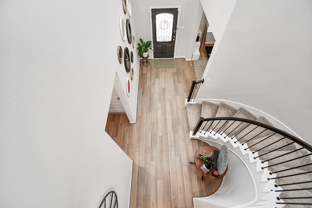 entryway with stairs, baseboards, and wood finished floors